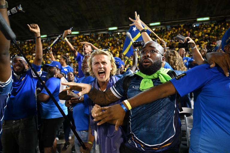 Cura&Atilde;&sect;ao fans celebrate World Cup 2026 qualification after a 0-0 draw with Jamaica at the National Stadium in Kingston, Jamaica on November 18, 2025. The tiny Caribbean nation of Curacao became the smallest country ever to qualify for the World Cup on November 18 as Haiti booked their return to the tournament for the first time in 52 years along with Panama.
A nerve-shredding finale to the CONCACAF qualifying campaign saw Curacao -- with a population of just 156,000 -- squeeze into next year's finals in the United States, Canada and Mexico with a 0-0 draw against Jamaica in Kingston. (Photo by Ricardo MAKYN / AFP) (Photo by RICARDO MAKYN/AFP via Getty Images)          
